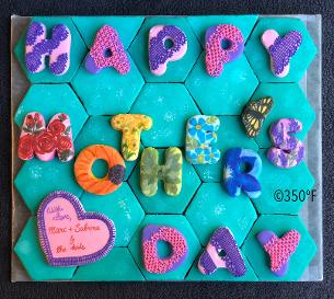Mother's Day themed cookie puzzle that spells out Happy Mother's Day with flowers and lace designed by Custom Cakes