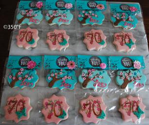 Floral cookies packaged beautifully in pink and turquoise as party favors for guests of a 70th birthday party