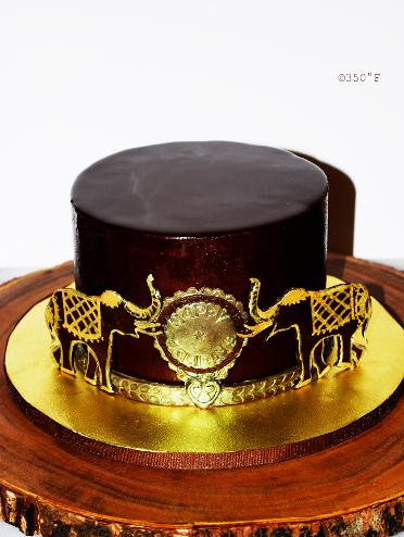 A holiday cake for an indonesian family - a chocolate mirror glaze cake with gold accents