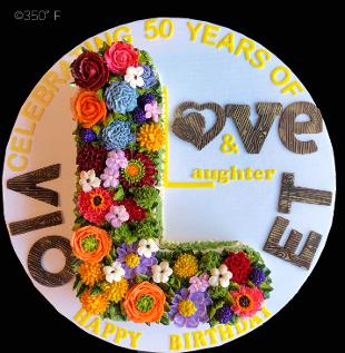 An L-shaped 50th birthday cake decorated with colorful buttercream flowers