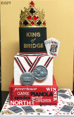 A tiered cake for an international bridge player's milestone birthday with sugar recreations of medals he won in his career.