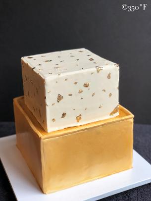 A tiered cake with gold leaf speckles for a sweet 16