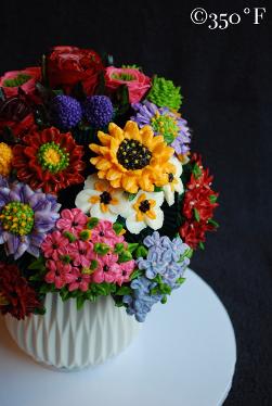 a cupcake bouquet with bright and colorful buttercream flowers created as a housewarming gift