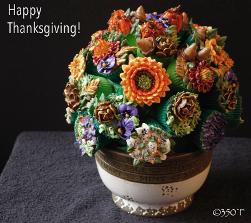 a thanksgiving theme cupcake bouquet with sunflowers, acorns, pansies and beautiful chrysanthemums