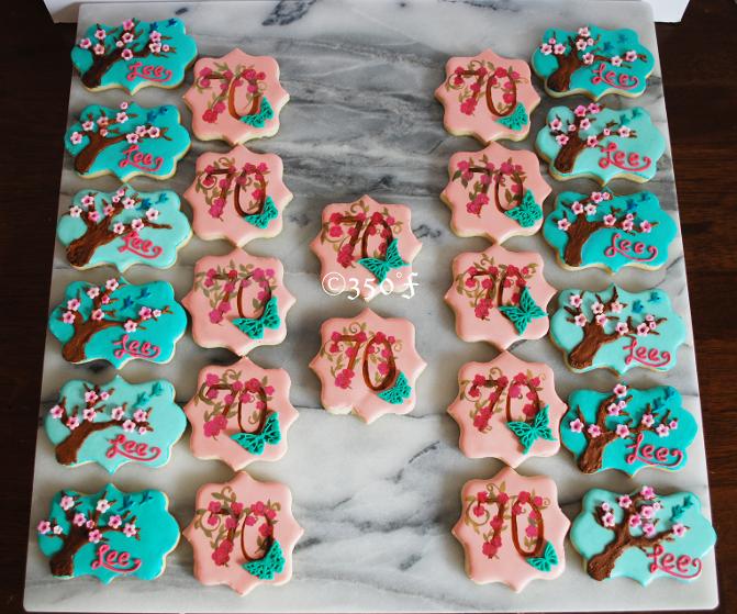 Custom Floral cookies in pink and turquoise ready to be packaged into pretty party favors for guests of a 70th birthday party