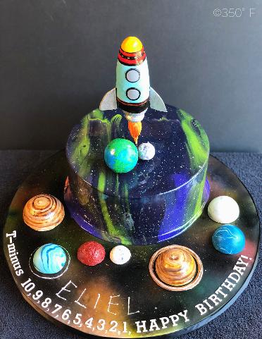 galaxy mirror glaze cake with planets and a spaceship for a 10th birthday party