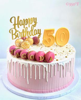 a 50th birthday cake in pink, white and gold