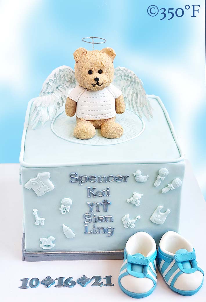 christening cake with angel bear and baby shoes