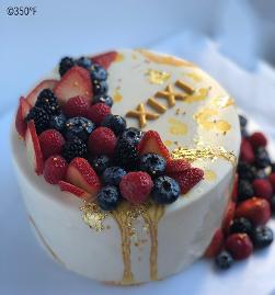 mirror glaze cake with fresh berries and 24K gold leaf decorations
