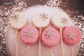 Snowflake cake pops adorn a dessert table at a Winter Wonderland Sweet 16 party