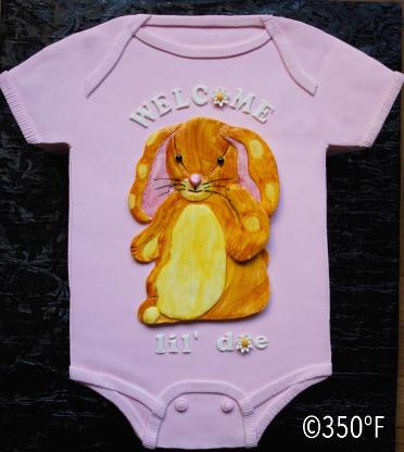 A sculpted onesie cake for a baby shower in Velveteen Rabbit theme
