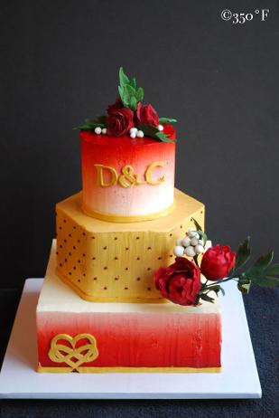 A buttercream wedding cake in wine red, white and gold with gum paste peonies