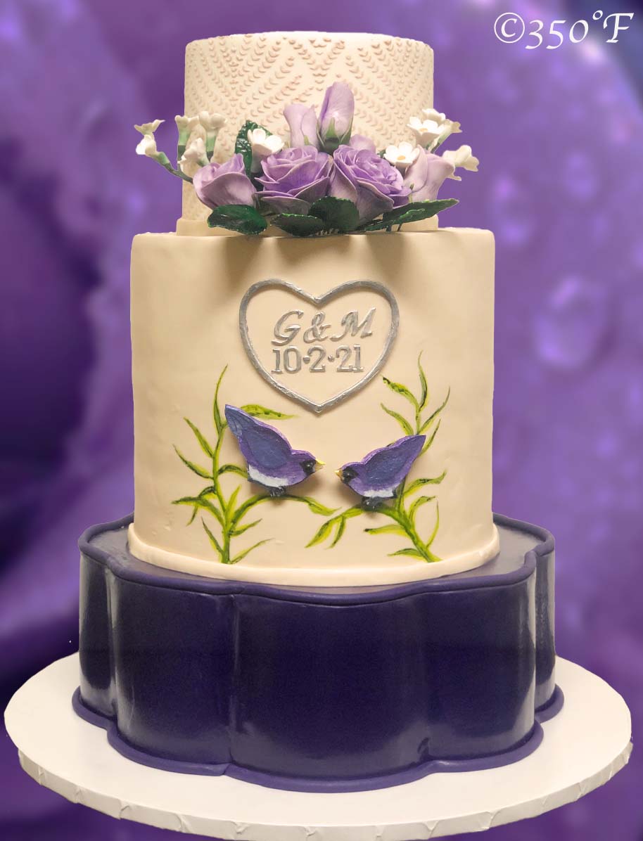 love birds themed wedding cake in purple, white and ivory color scheme