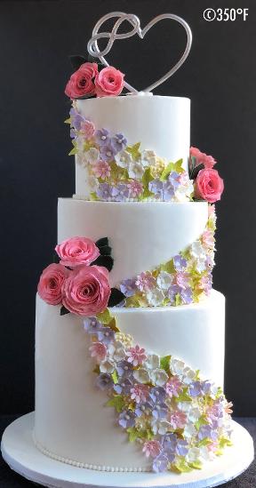 A floral wedding cake with a handmade edible cake topper