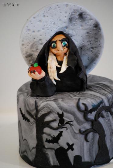 The wicked witch presenting a poison apple on Halloween - a marble fondant cake